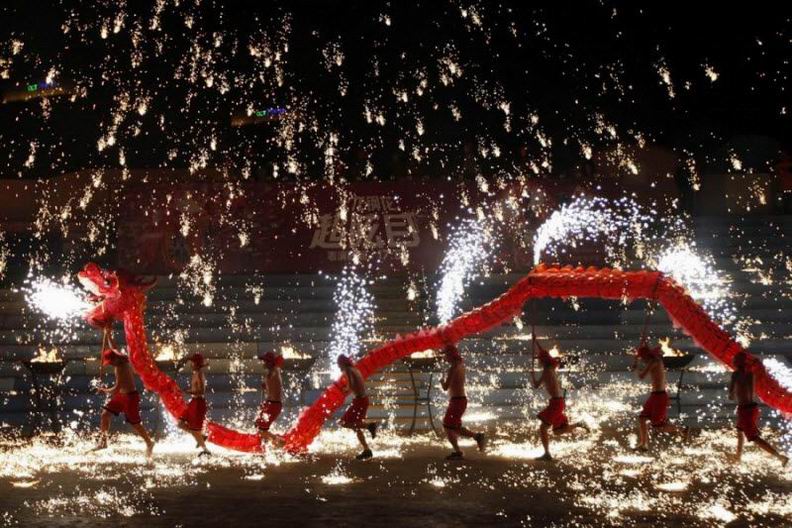 Участники танца огненного дракона на празднестве в Пекине